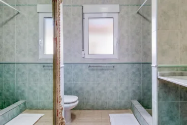 Baño de la vivienda con plato de ducha y espejo