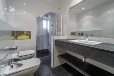 Gran baño en suite con plato de ducha y mampara a medida