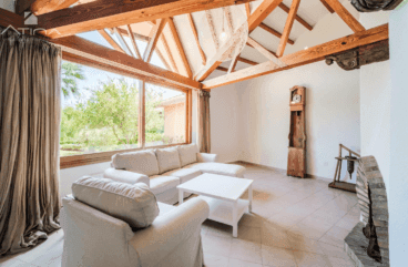 Amplio y luminoso salón con techos altos y vigas de madera