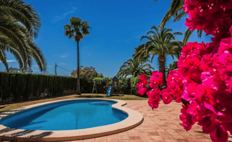 Exterior de la villa con piscina y jardín