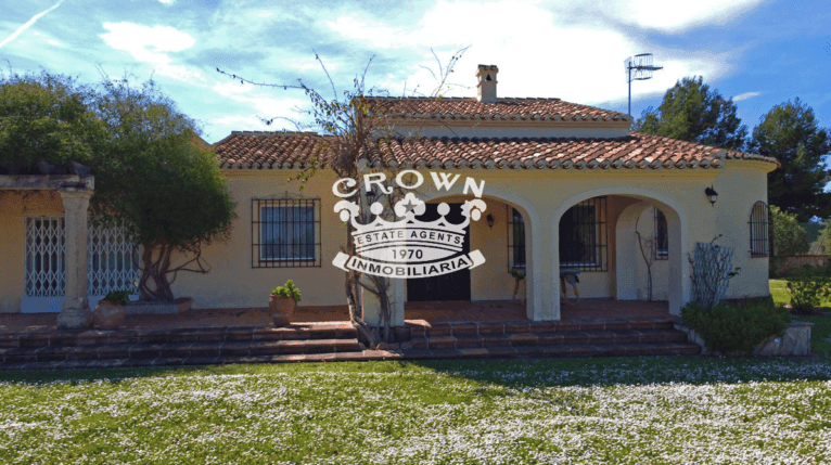 Fachada del chalet con un jardín muy vistoso