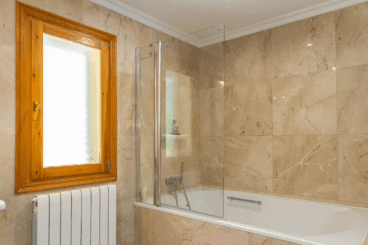 Baño de la vivienda equipado con bañera y mampara de cristal