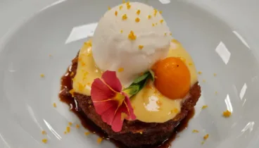 Un postre con crema de naranja y helado de queso de cabra