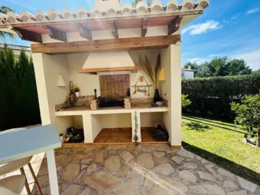 Zona de barbacoa exterior en el jardín de la vivienda