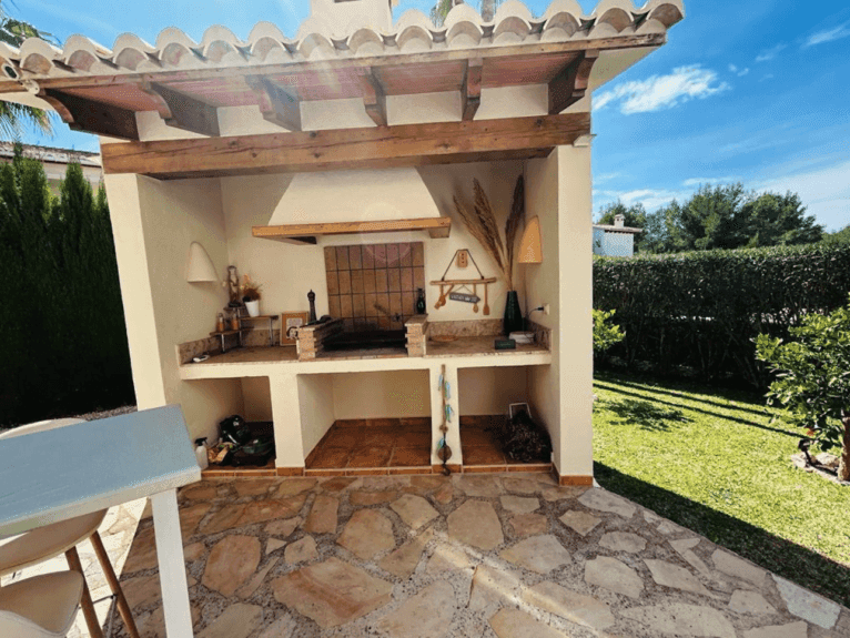 Zona de barbacoa exterior en el jardín de la vivienda