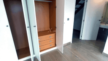 Dormitorio con armarios empotrados y baño en suite