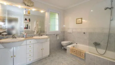 Amplio cuarto de baño con bañera y mampara