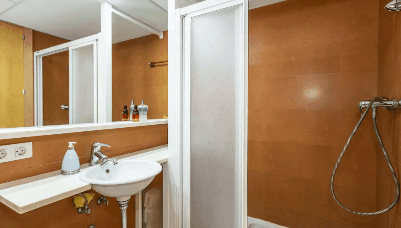 Cuarto de baño en tonos marrones con ducha