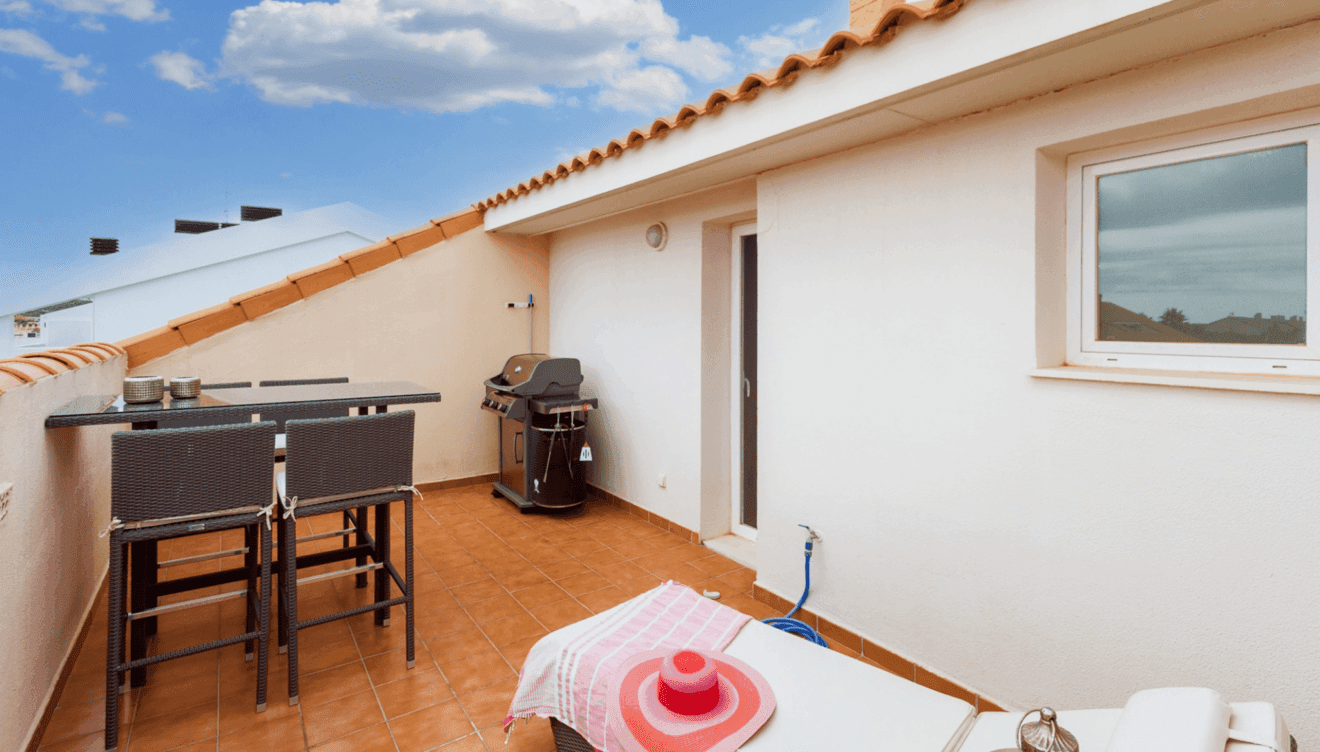 Terraza exterior con cómodas tumbonas y zona de barbacoa
