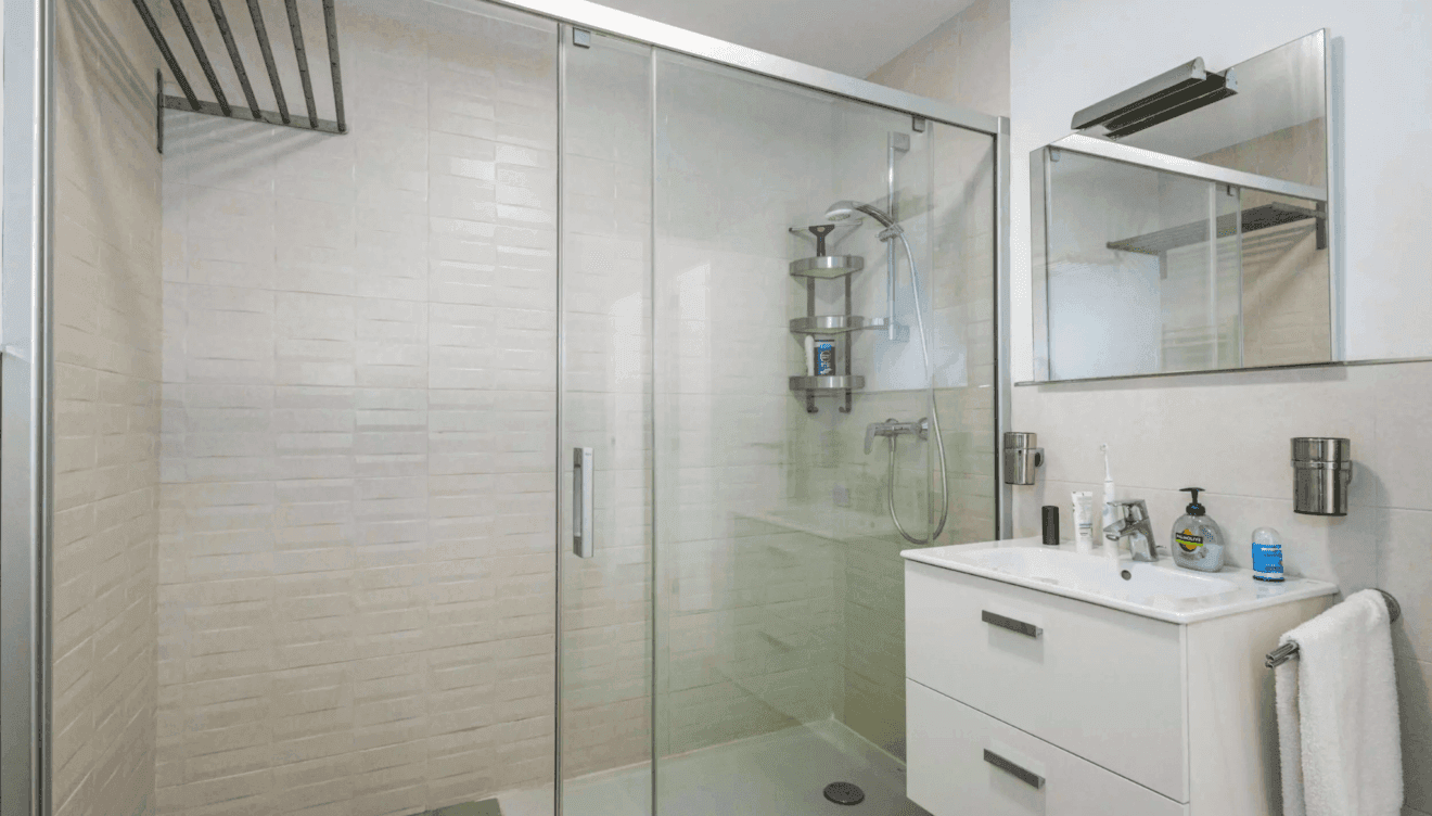 Cuarto de baño con ducha en tonos crema