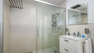 Cuarto de baño con ducha en tonos crema
