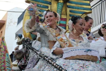 Una reina en el desfile de Carrozas 75 aniversario Fogueres lanzando chucherías