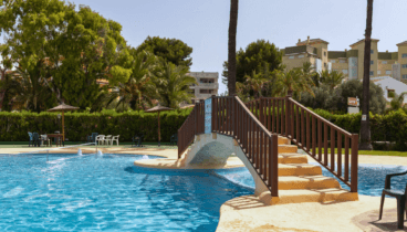 Piscina comunitaria rodeada de jardines perfectamente cuidados