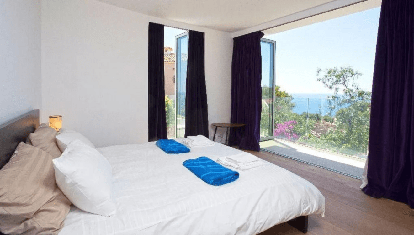 El dormitorio principal, espacioso y luminoso, cuenta con grandes ventanales que permiten disfrutar de vistas espectaculares al mar y la montaña
