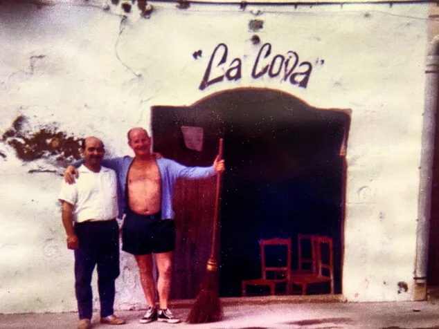 Imagen: Vicente 'El Almirant'  y un cliente de verano, en una simpática instantánea bajo el letrero pintado por Soler Blasco | Foto Vicente Segarra Gavilá