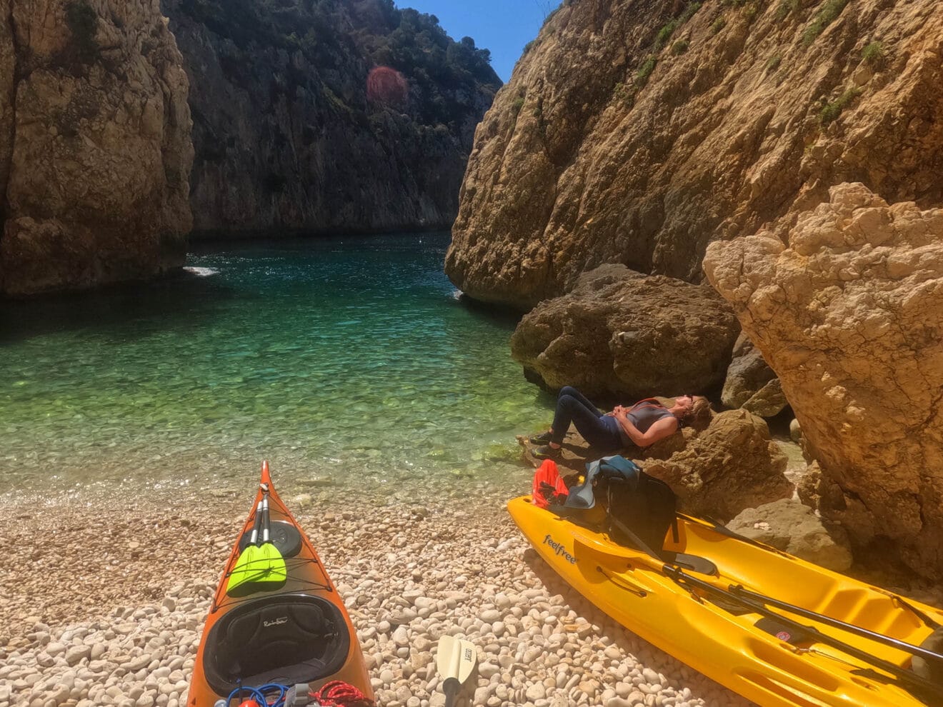 Excursionista descansando en un kayak en una cala de Xàbia