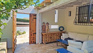 Acceso a la casa con jardín y bancos