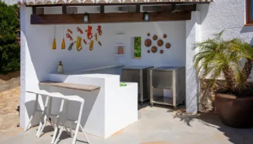 Cocina exterior con barra y parrilla