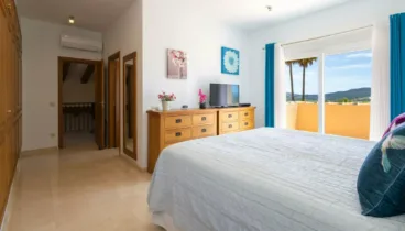 Dormitorio con acabados cálidos y acceso al exterior