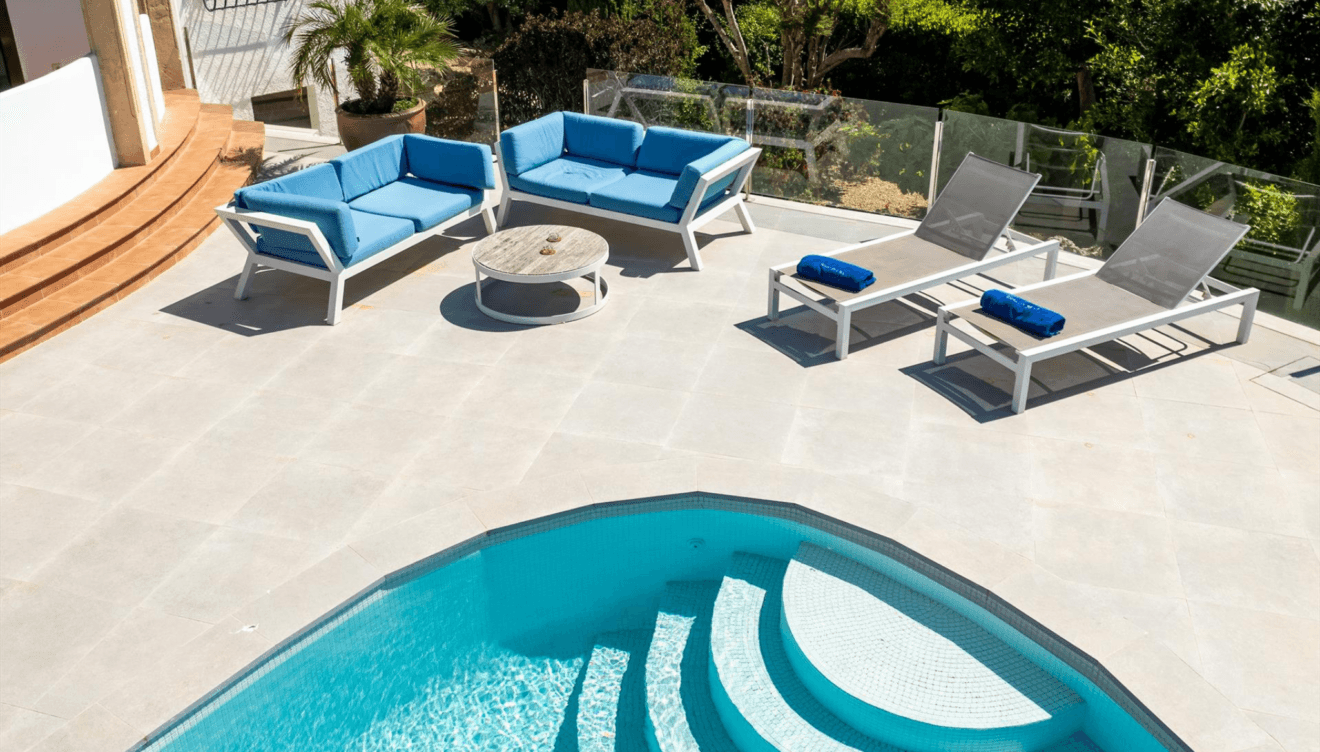 Terraza junto a la piscina con tumbonas