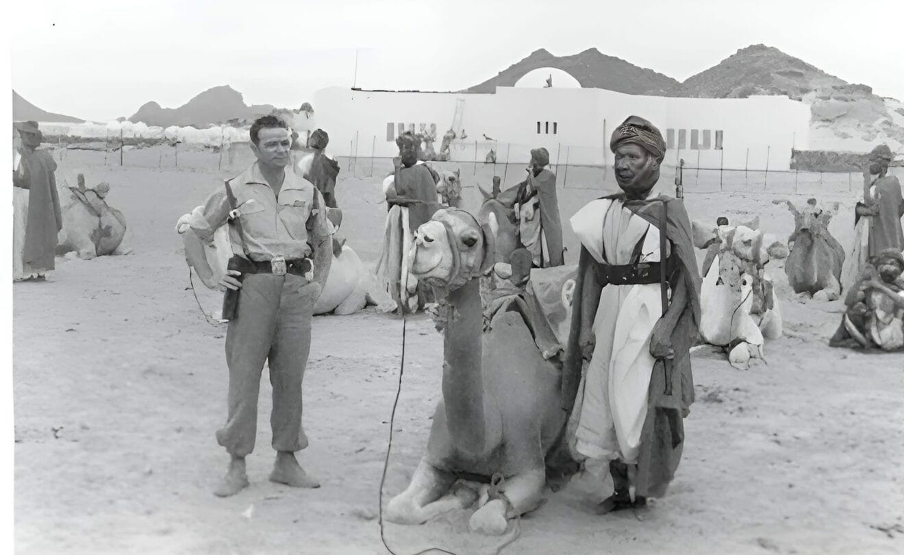 Un legionario posa junto a saharaius delante de unas instalaciones del Ejército español. Años 70. Fotografía perteneciente a la Asociación Nacional de Veteranos de la Mili en el Sahara