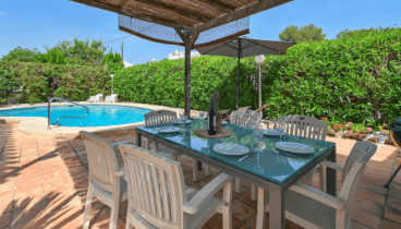 Comedor exterior en villa con jardín y terraza