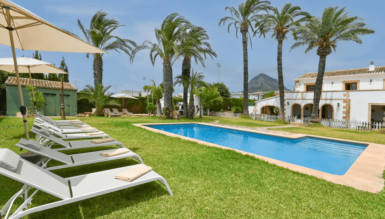 Piscina privada rodeada de vegetación y tumbonas