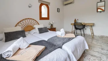 Dormitorio con camas individuales y baño en suite