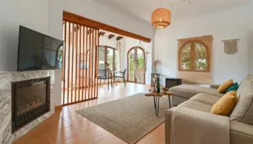 Salón principal con ventanales y chimenea de leña
