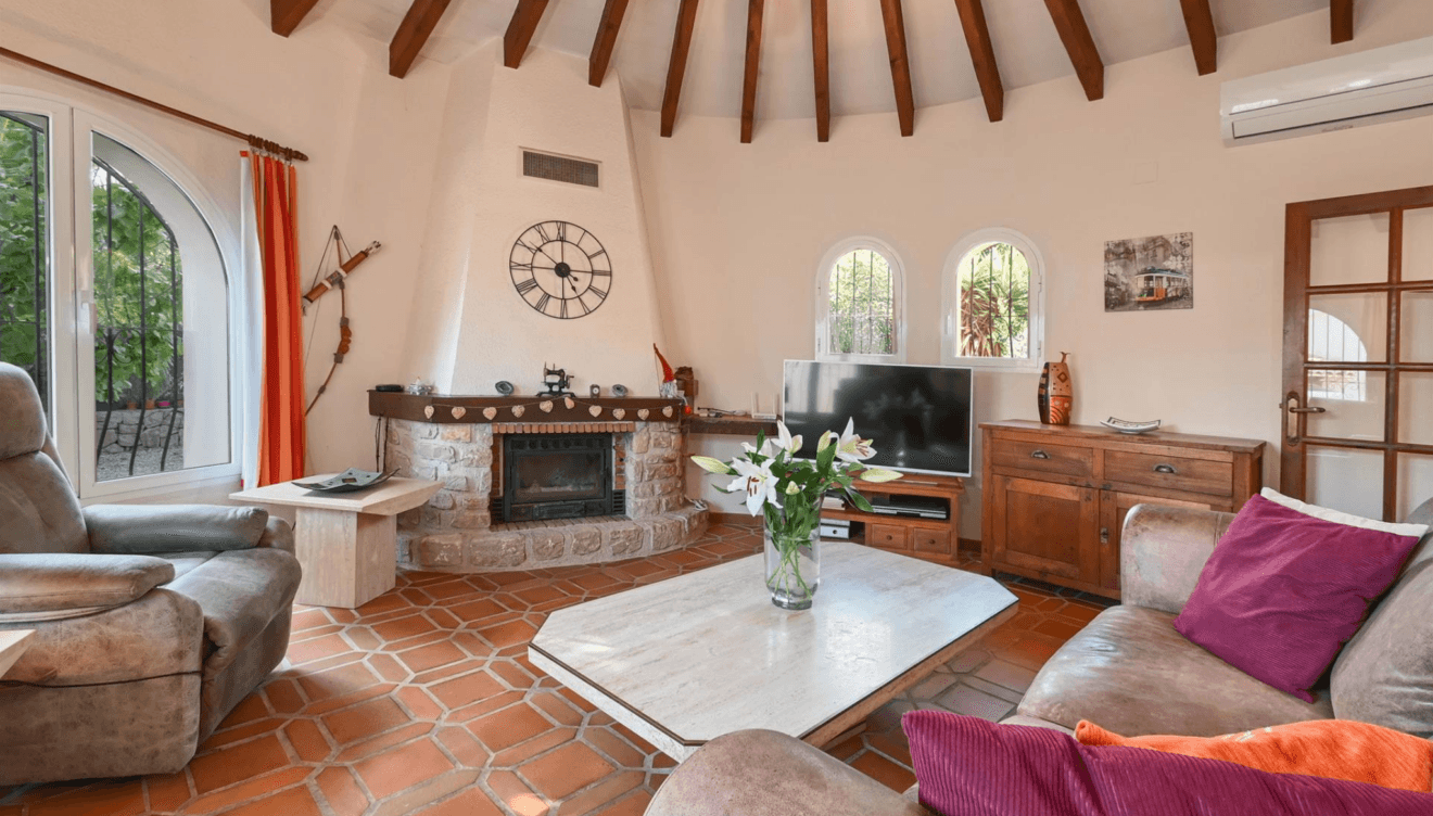 Salón acogedor con chimenea en Villa La Siesta Jávea