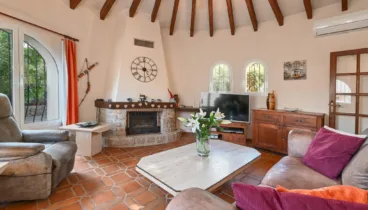 Salón acogedor con chimenea en Villa La Siesta Jávea