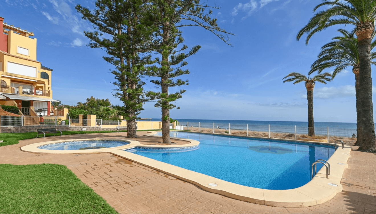 Jardines con césped y árboles junto a la piscina en Casa Denimar Dénia