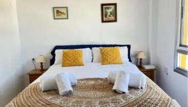 Dormitorio principal con cama doble y televisión