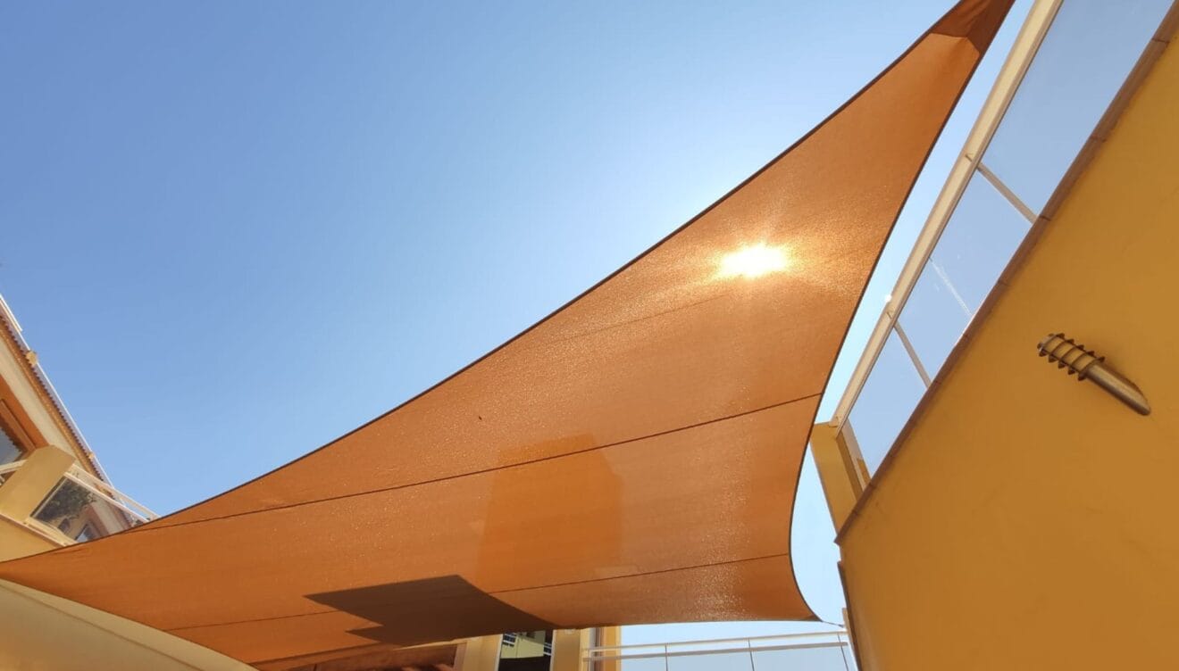 Instalación de toldo vela de diseño para sombra en jardines modernos de Denia