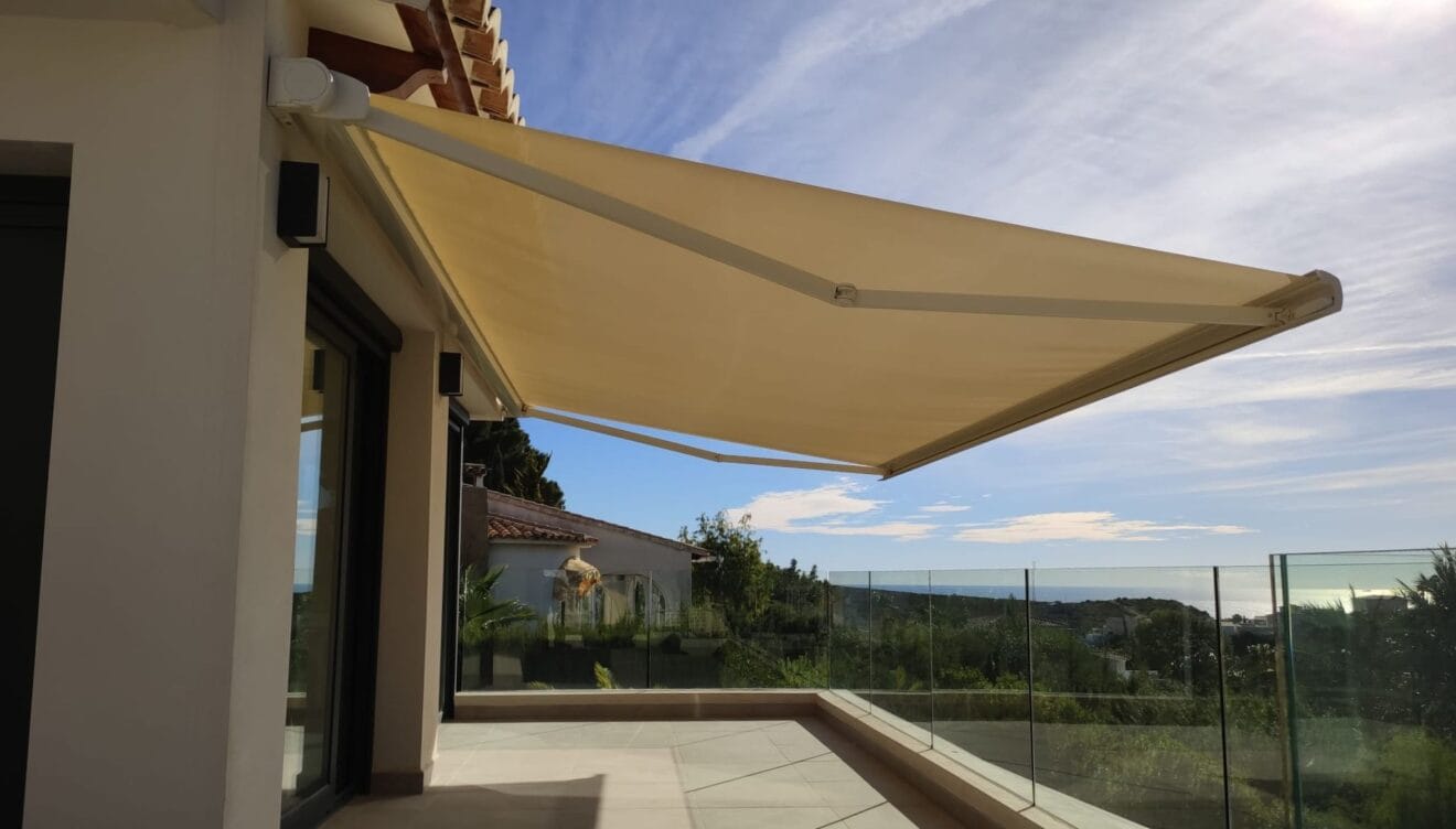 Instalación de toldos de brazos articulados en terraza con vistas al mar
