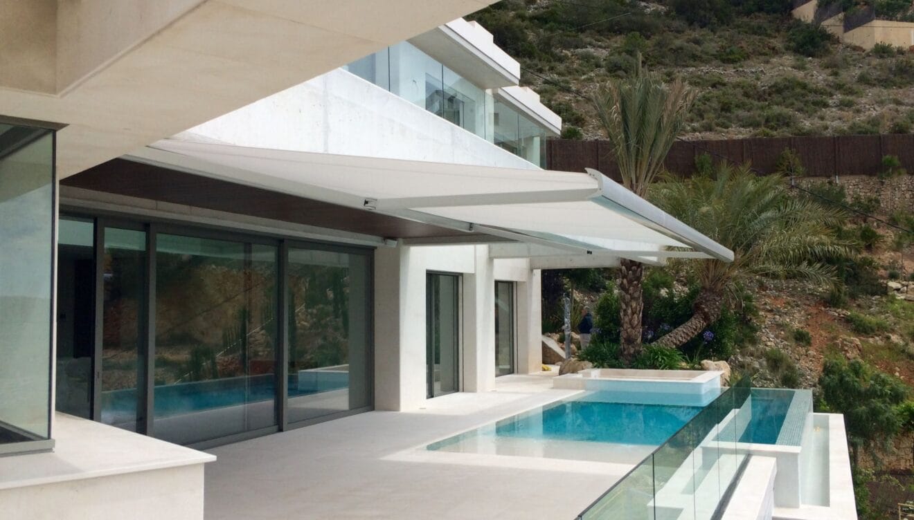 Toldo de diseño minimalista para protección solar en zona de relax junto a la piscina