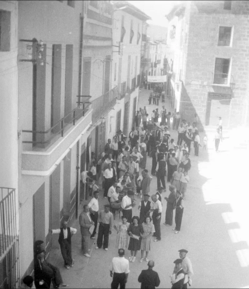 Plaça de Baix. A la izq. se pueden observar las puertas de 'La Tómbola'  abiertas con gente. Años 40. AMX