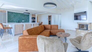 Salón luminoso con chimenea y grandes ventanales de seguridad