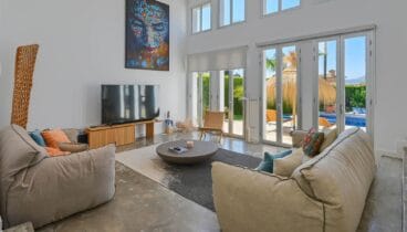 Área de estar acogedora con grandes ventanales hacia el jardín privado