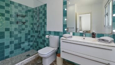 Baño en suite luminoso con lavabo doble y espejo de gran formato