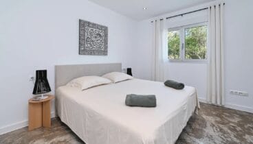 Dormitorio amplio con cama doble y decoración en tonos neutros