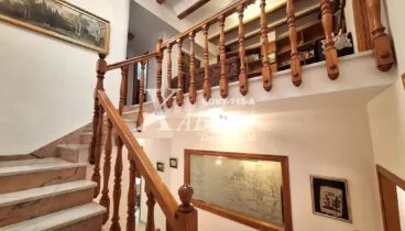 Escalera señorial de estilo tradicional que conecta las plantas