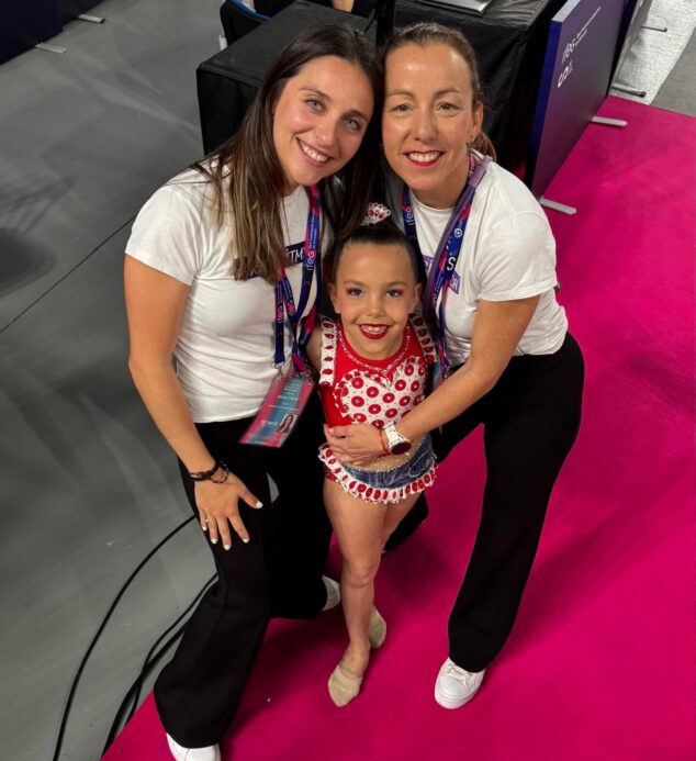 La gimnasta Iris y sus dos entrenadoras sonríen a cámara en el Campeonato Nacional de Oviedo.