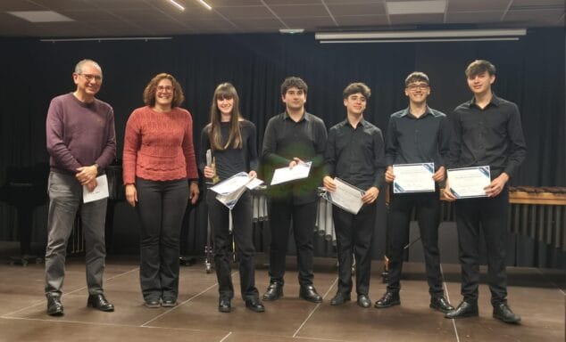 Estudiants i professors del Conservatori de Xàbia en un escenari, sostenint diplomes després de la fase de centre del XV Concurs Intercentres.