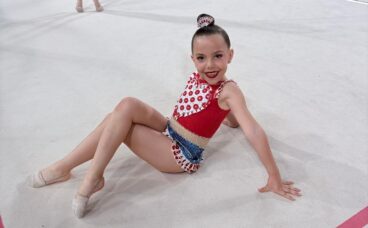 Iris, joven gimnasta rítmica, sonriendo sentada en el tapiz del Campeonato Nacional en Oviedo.