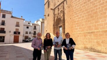 Representantes municipales y de la Cofradía del Nazareno posan frente a la iglesia de Xàbia con el programa oficial de las fiestas
