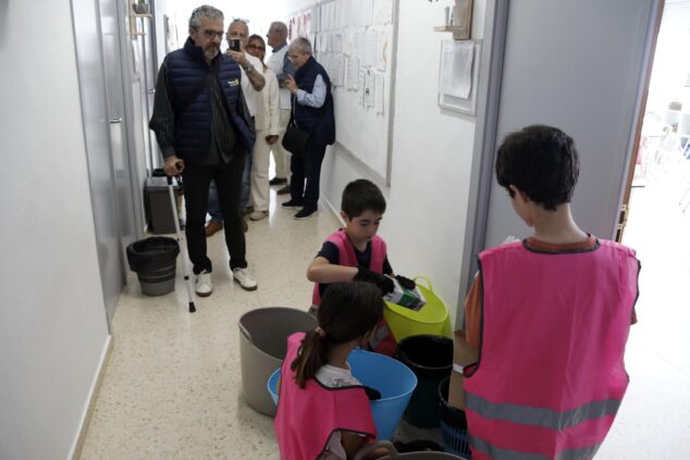 Imagen: Alumnos del colegio Port de Xàbia separando residuos en el pasillo con miembros del Rotary Club observando