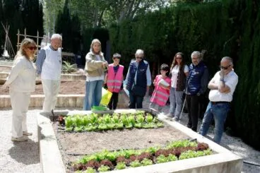 Integrantes del Rotary Club Jávea, la directora del centro y alumnos del proyecto "Guardianes del Planeta" observan el huerto escolar de lechugas.