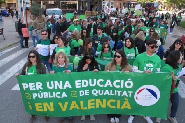 Manifestantes sostienen una gran pancarta verde con el lema "Per una educació pública de qualitat en valencià" durante una protesta en Dénia.