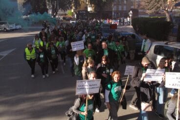 Manifestantes con camisetas verdes y pancartas durante una huelga educativa.
